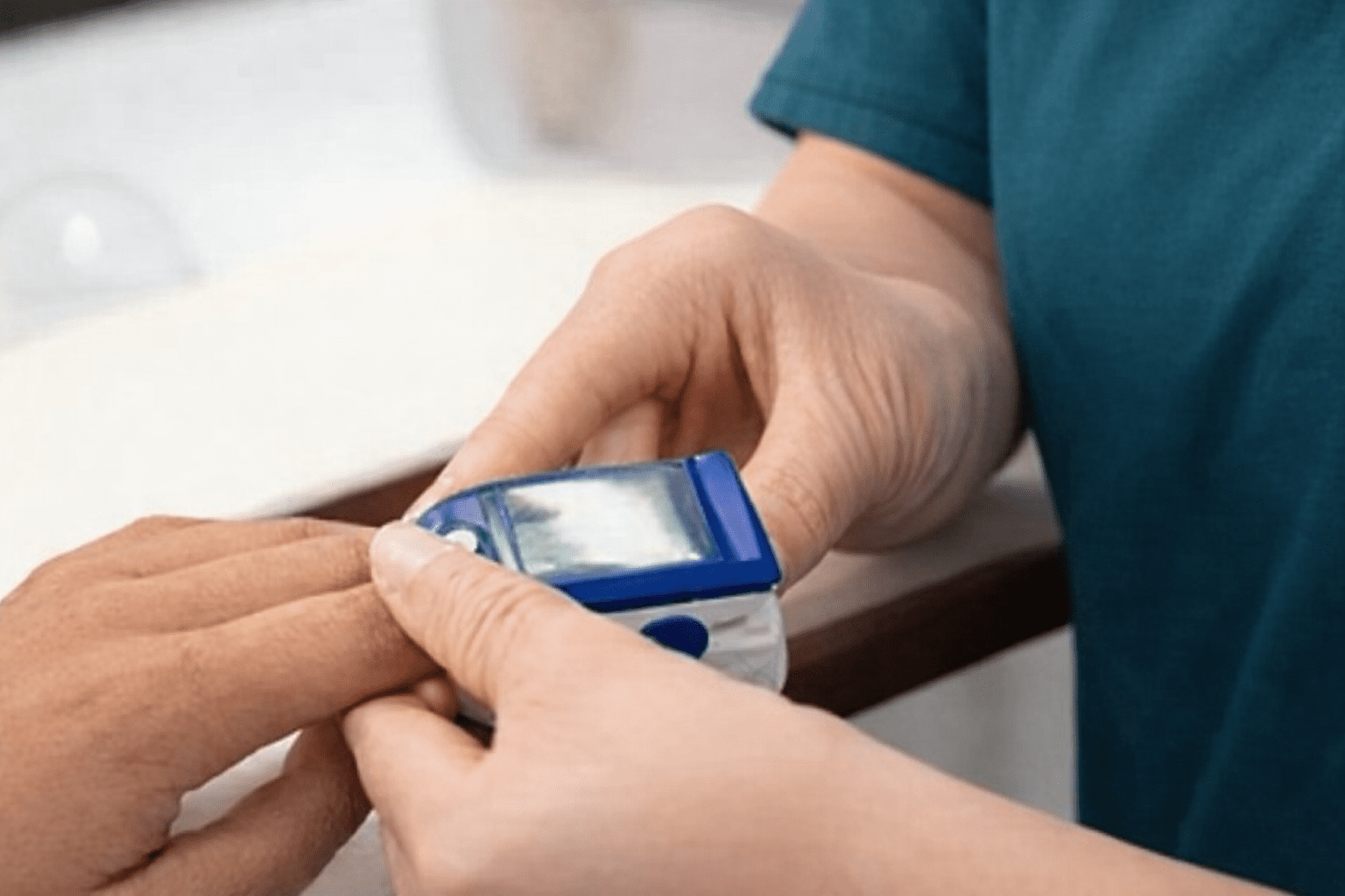 Nurse using a diabetes monitoring device to check a patient’s blood glucose levels