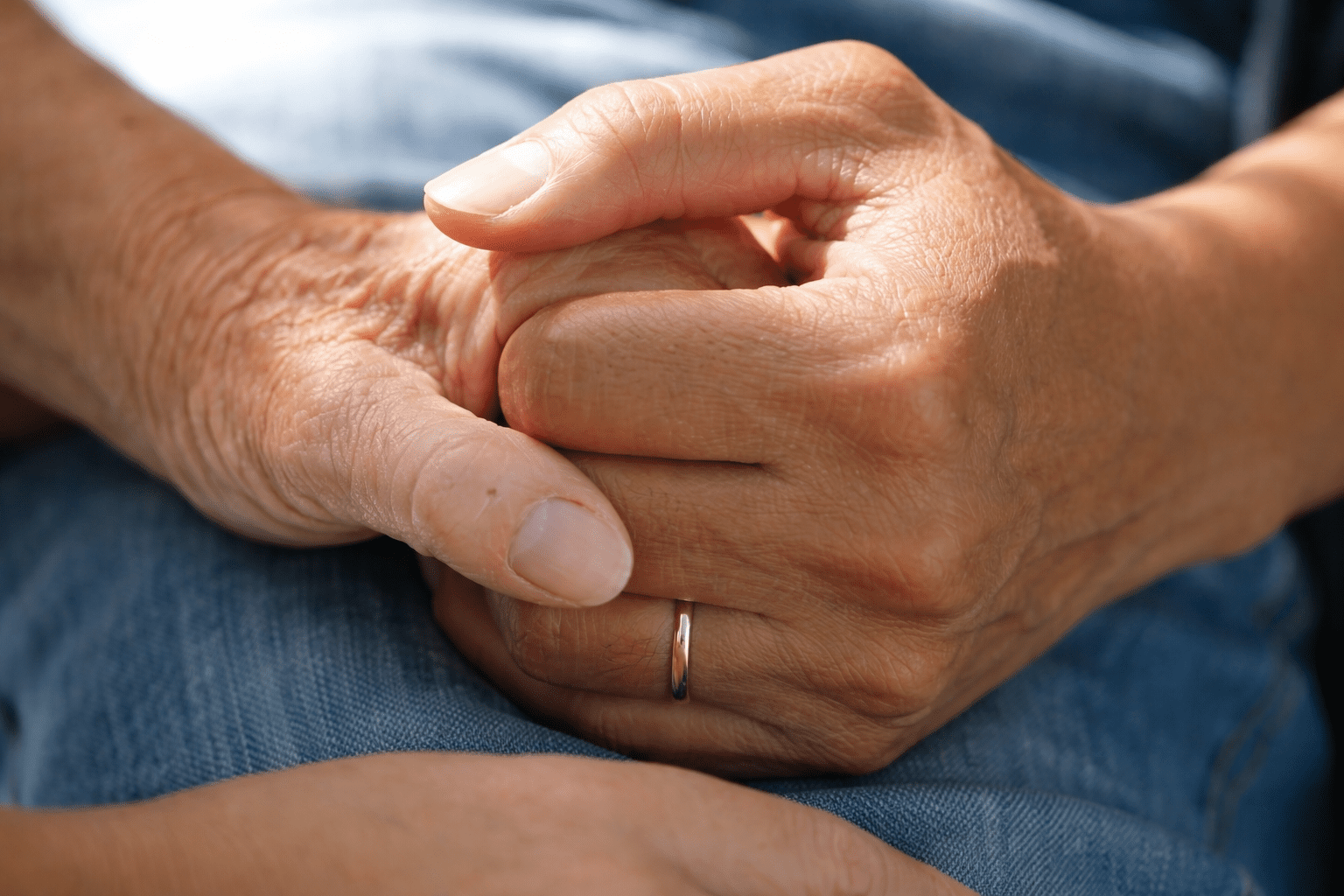 a caregiver’s hand gently holding a senior patient's hand, offering comfort and support