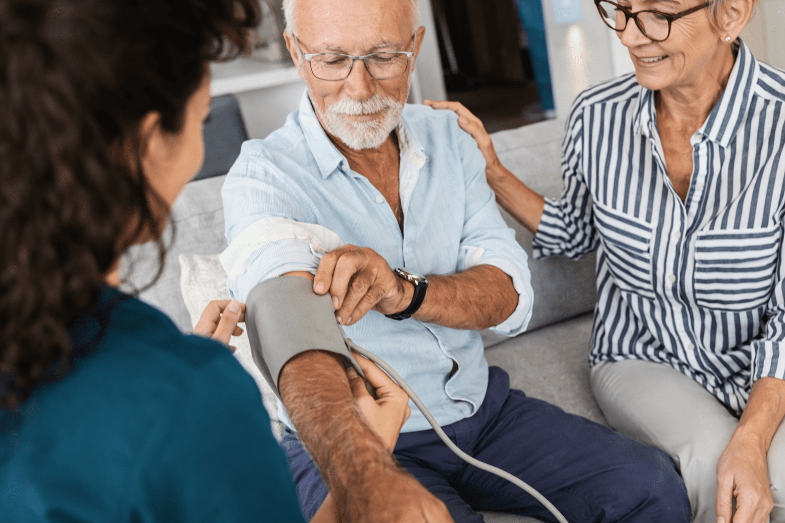 Healthcare worker checking an elderly man’s blood pressure