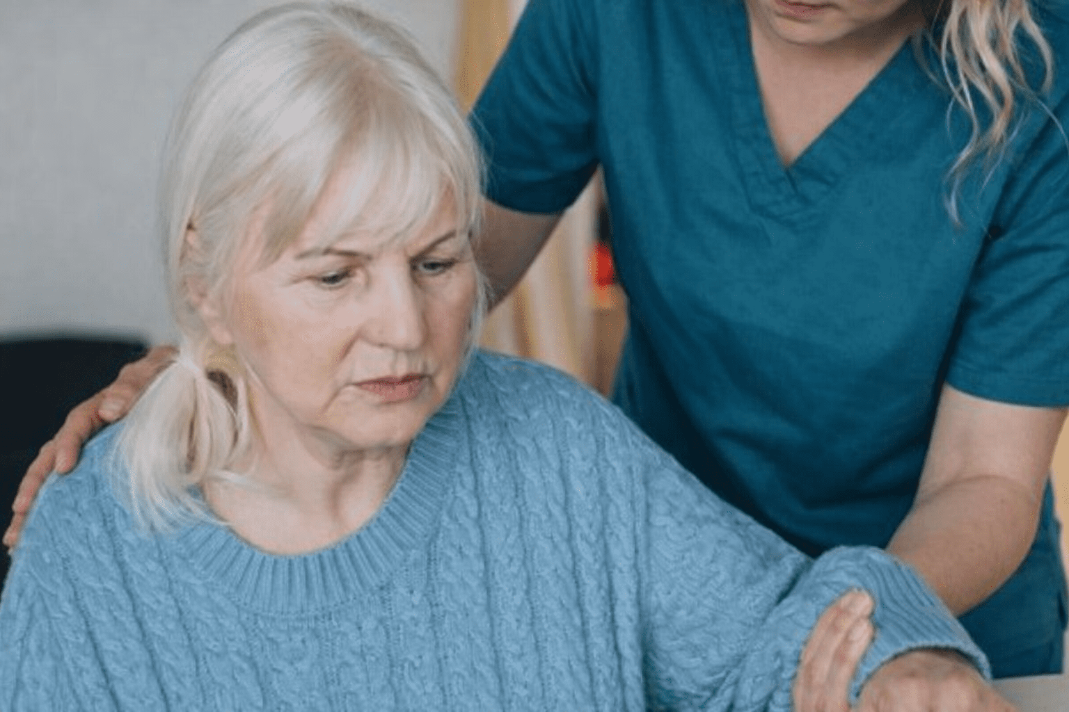 Healthcare worker assisting an elderly woman to stand safely, supporting mobility and swallowing care
